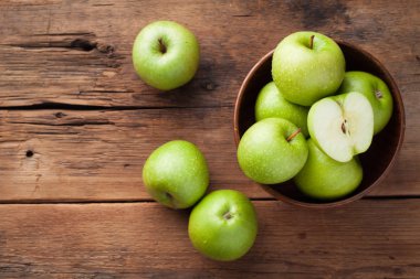 Eski rustik masa ahşap bir kasede olgun yeşil elma. Ahşap arka plan üzerinde yararlı meyve. Kopya alanı ile Üstten Görünüm