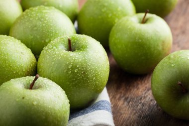 Eski rustik masa ahşap bir kasede olgun yeşil elma. Ahşap arka plan üzerinde yararlı meyve. Üstten Görünüm