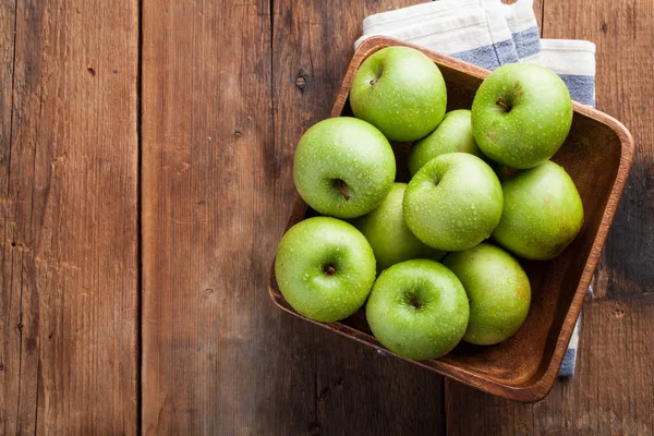 Apel hijau matang dalam mangkuk kayu di atas meja pedesaan tua. Buah-buahan yang berguna pada latar belakang kayu. Tampilan atas dengan ruang penyalinan — Stok Foto