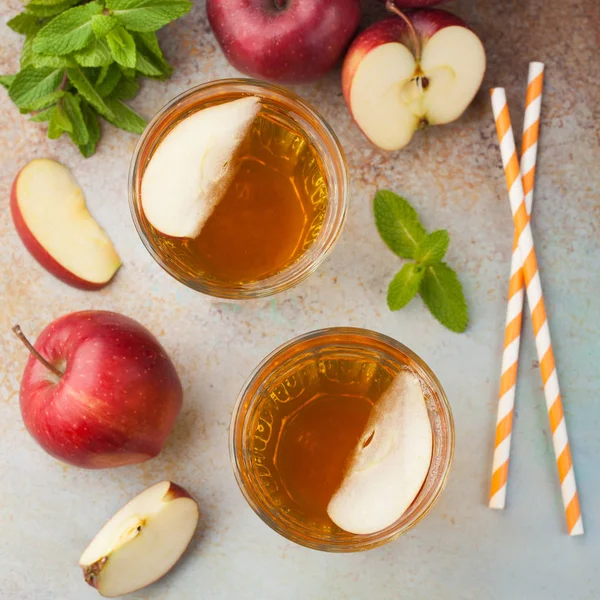 Dua gelas jus apel merah dengan mint dan es di meja tua berkarat. Minuman ringan dengan latar belakang biru. Tampilan atas — Stok Foto