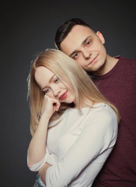 güzel, genç bir çift aşık stüdyoda koyu arka plan üzerinde poz portresi