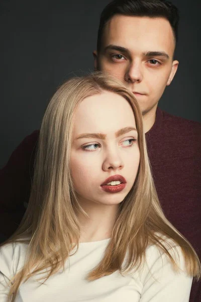 Retrato de una hermosa pareja joven enamorada posando en el estudio sobre fondo oscuro — Foto de Stock