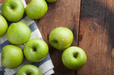 Eski rustik masa ahşap bir kasede olgun yeşil elma. Ahşap arka plan üzerinde yararlı meyve. Kopya alanı ile Üstten Görünüm