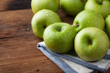 Eski rustik masa ahşap bir kasede olgun yeşil elma. Ahşap arka plan üzerinde yararlı meyve. kopya alanı ile