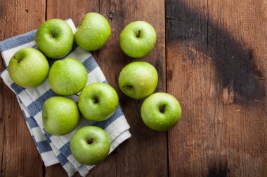 Eski rustik masa ahşap bir kasede olgun yeşil elma. Ahşap arka plan üzerinde yararlı meyve. Kopya alanı ile Üstten Görünüm