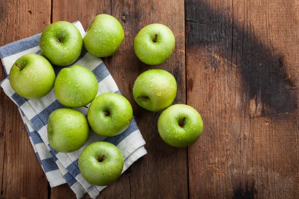 Eski rustik masa ahşap bir kasede olgun yeşil elma. Ahşap arka plan üzerinde yararlı meyve. Kopya alanı ile Üstten Görünüm