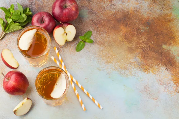 Dua gelas jus apel merah dengan mint dan es di meja tua berkarat. Minuman ringan dengan latar belakang biru. Tampilan atas dengan ruang penyalinan — Stok Foto