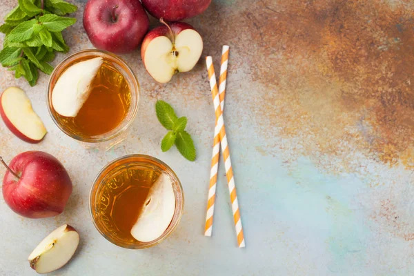 Dua gelas jus apel merah dengan mint dan es di meja tua berkarat. Minuman ringan dengan latar belakang biru. Tampilan atas dengan ruang penyalinan — Stok Foto