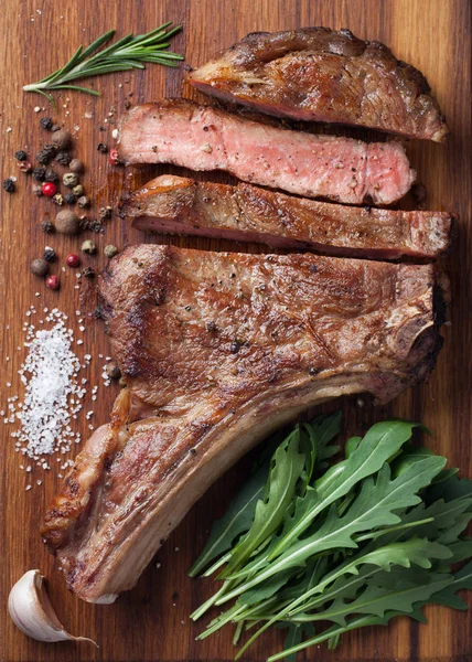 Steak de bœuf de cow-boy grillé, herbes et épices sur une planche en bois. Vue du dessus — Photo