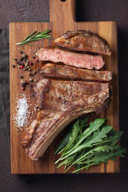 Izgara kovboy sığır eti biftek, otlar ve baharatlar ahşap bir gemide. T
