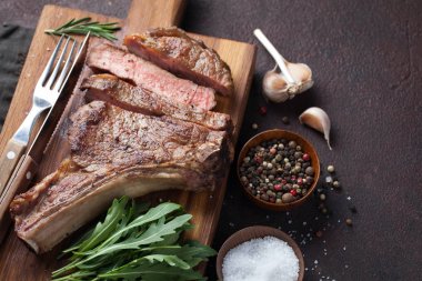 Kovboy sığır eti biftek, otlar ve baharatlar geri karanlık bir taş üzerinde ızgara