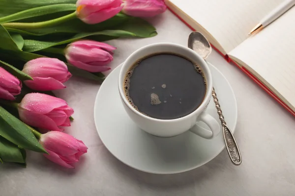 Biurko do pracy kobieta kawy kubek, Notatnik i wiosna tulip kwiaty widoku z góry w stylu płaski świeckich — Zdjęcie stockowe