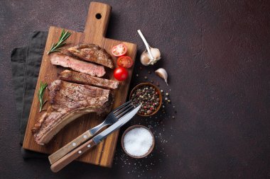 Kovboy sığır eti biftek, otlar ve baharatlar geri karanlık bir taş üzerinde ızgara