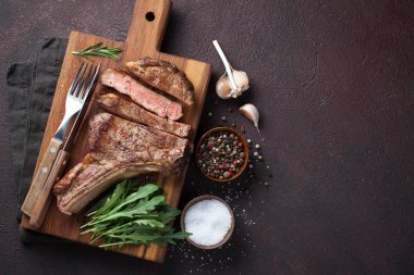 Kovboy sığır eti biftek, otlar ve baharatlar geri karanlık bir taş üzerinde ızgara