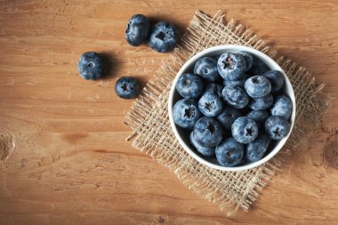 Ahşap masa arka plan üzerinde yaban mersini. Olgun ve sulu taze yaban mersini closeup aldı. Kopya alanı ile çilek closeup Üstten Görünüm