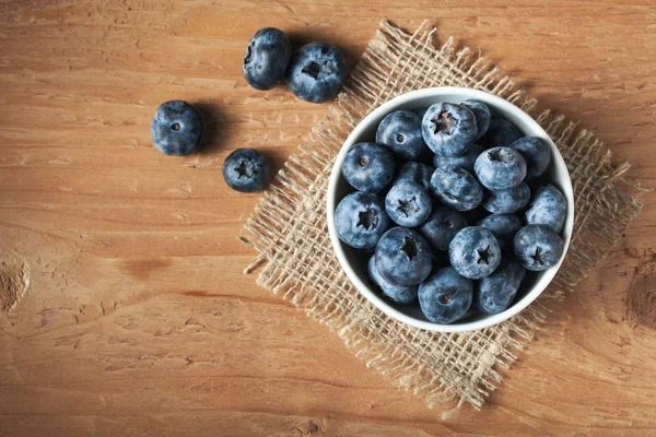 Blueberry on wooden table background. Ripe and juicy fresh picked blueberries closeup. Berries closeup top view with copy space — Stock Photo, Image