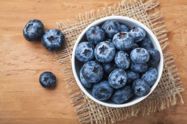 Blueberry on wooden table background. Ripe and juicy fresh picked blueberries closeup. Berries closeup top view with copy space — Stock Photo, Image