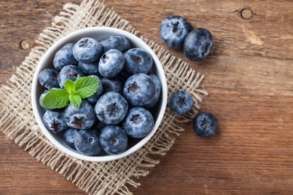 Blueberry on wooden table background. Ripe and juicy fresh picked blueberries closeup. Berries closeup top view with copy space — Stock Photo, Image