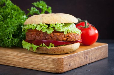Taze vejetaryen Burger ile domates, salatalık, marul ve vegan pirzola ahşap tahta üzerinde