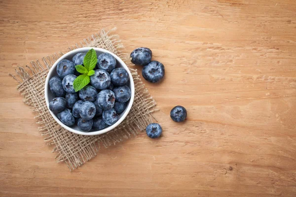 Blueberry on wooden table background. Ripe and juicy fresh picked blueberries closeup. Berries closeup top view with copy space — Stock Photo, Image