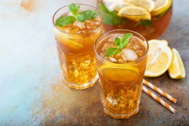 Limon, nane ve uzun boylu gözlük buz ile geleneksel buzlu çay. İki bardak eski paslı arka plan üzerinde serin yaz içkiyle. Kopya alanı ile