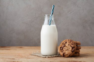 Şişe süt ve Çikolata parçalı kurabiye kopya alanı ile koyu arka plan üzerinde
