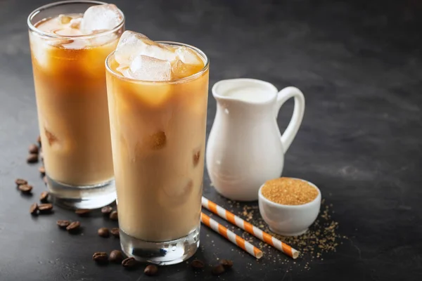 Eiskaffee in einem hohen Glas mit Sahne, braunem Zucker und Kaffeebohnen. Kalter Sommerdrink auf dunklem Hintergrund. mit Kopierraum — Stockfoto