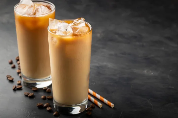 Eiskaffee in einem hohen Glas mit Sahne, braunem Zucker und Kaffeebohnen. Kalter Sommerdrink auf dunklem Hintergrund. mit Kopierraum — Stockfoto