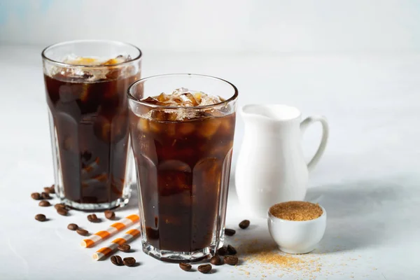 Кофе со льдом в высоком стакане со сливками и кофейными зёрнами. Холодный летний напиток на светло-голубом фоне — стоковое фото
