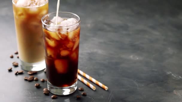 Dos vasos de café frío sobre un fondo negro. Café con helado o leche. cámara lenta — Vídeos de Stock