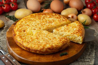 Patates ve soğanlı İspanyol omleti, tipik İspanyol mutfağı. Tortilla espanola. Kırsal karanlık arka plan. Üst görünüm