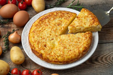 Patates ve soğanlı İspanyol omleti, tipik İspanyol mutfağı. Tortilla espanola. Kırsal karanlık arka plan. Üst görünüm