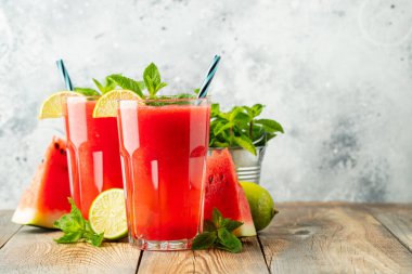 Kireç ve nane ile Karpuz slushie, hafif bir arka plan üzerinde uzun bardak yaz ferahlatıcı içecek. Kopya alanı ile tatlı soğuk smoothie.