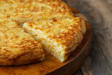 Patates ve soğanlı İspanyol omleti, tipik İspanyol mutfağı. Tortilla espanola. Kırsal koyu arkaplan.