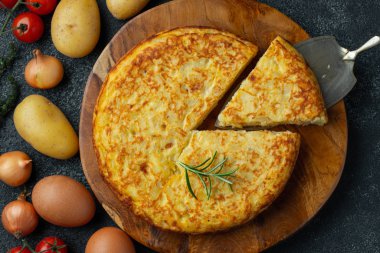 Patates ve soğanlı İspanyol omleti, tipik İspanyol mutfağı. Tortilla espanola. Kırsal karanlık arka plan. Üst görünüm.