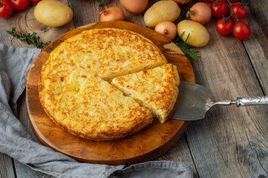 Patates ve soğanlı İspanyol omleti, tipik İspanyol mutfağı. Tortilla espanola. Kırsal karanlık arka plan. Üst görünüm