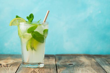 Ev yapımı limonata ya da mojito kokteyli, kireç, nane ve buz küpleriyle ahşap bir kırsal masada. Taze yaz içkisi. kopyalama alanı ile.