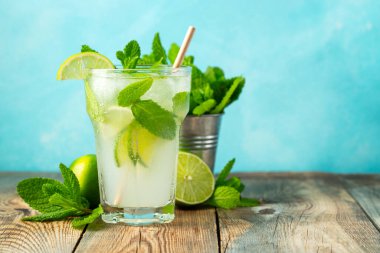 Ev yapımı limonata ya da mojito kokteyli, kireç, nane ve buz küpleriyle ahşap bir kırsal masada. Taze yaz içkisi. kopyalama alanı ile