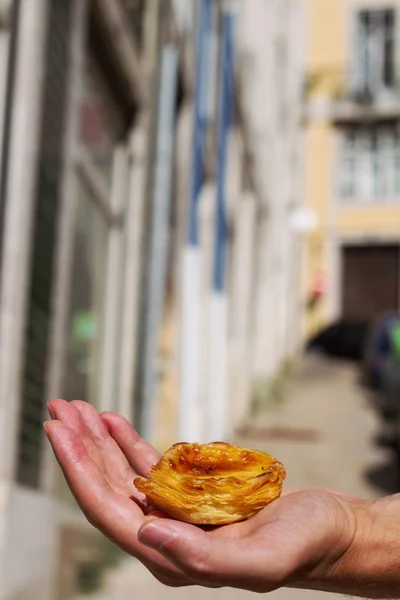 Portuguese dessert pastel de nata in hand — Stock Photo, Image