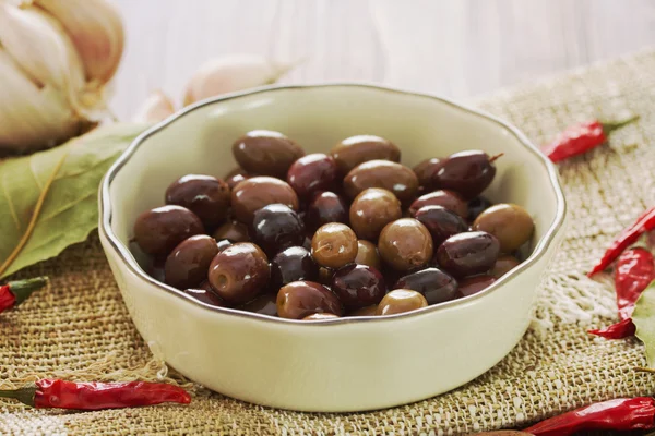 Оливки в белом блюде с чесноком — стоковое фото