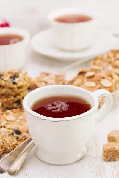 Šálek čaje s zdravé cukroví na bílém pozadí dřevěná — Stock fotografie