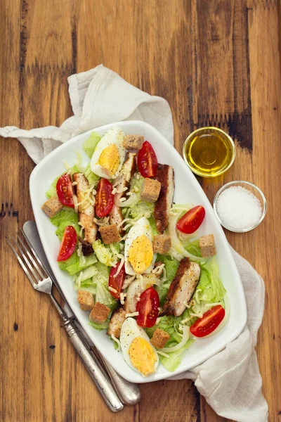 Куриный салат с вареным яйцом на белом блюде — стоковое фото