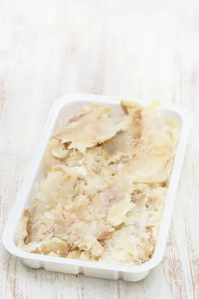 Bacalao salado sobre plato de plástico sobre fondo blanco — Foto de Stock