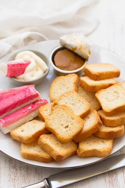 Spuntino su piatto bianco su sfondo di legno — Foto Stock