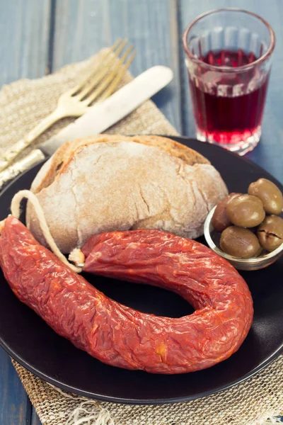 Uzená klobása s chlebem, olivami a červeným vínem — Stock fotografie