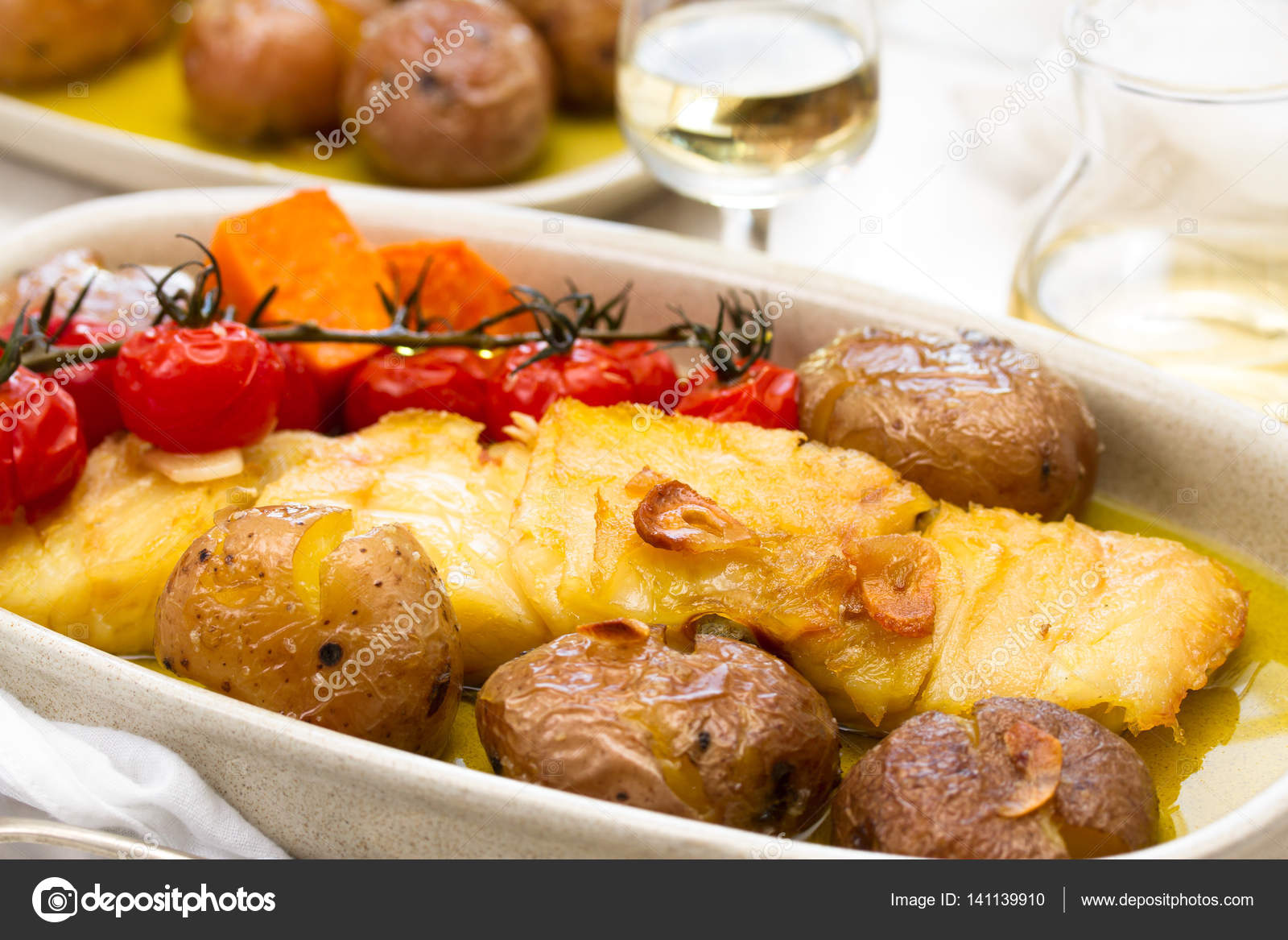 Cod fish with potato and tomato cherry on dish Stock Photo by