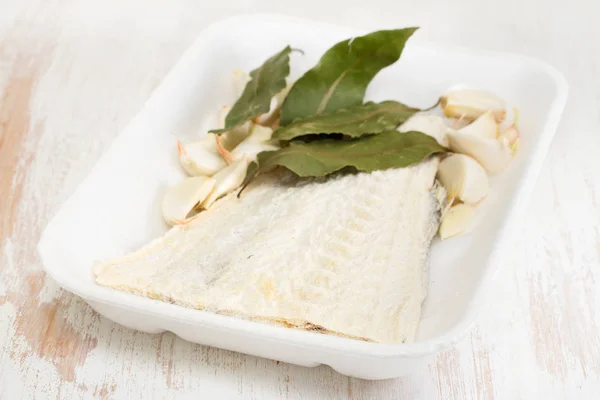 Bacalao salado con hoja de laurel en el plato — Foto de Stock