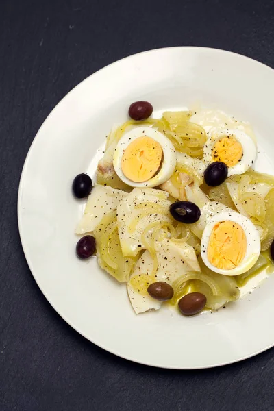 Cod fish with potato, egg and olives on plate — Stock Photo, Image