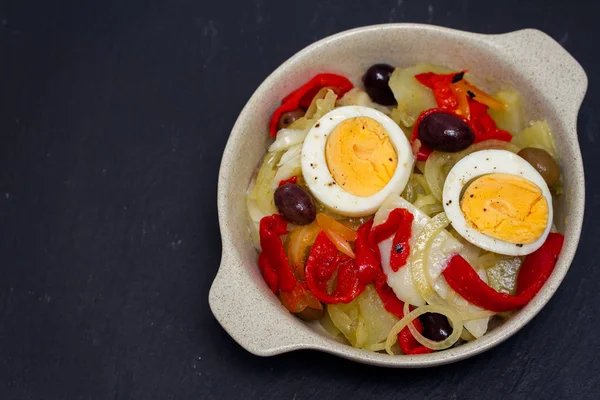 Dorsz z ziemniaków, czerwonej papryki, jajka i oliwki na danie — Zdjęcie stockowe