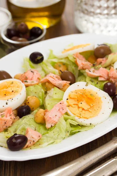 Salad with salmon, eggs and olives on white dish — Stock Photo, Image